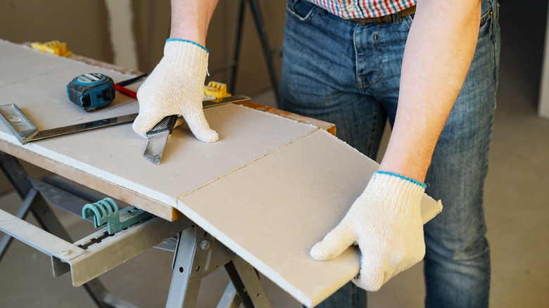 Person cuts a drywall sheet