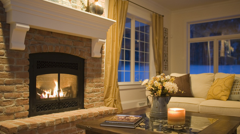 Fireplace with protective glass doors in tan-toned living room