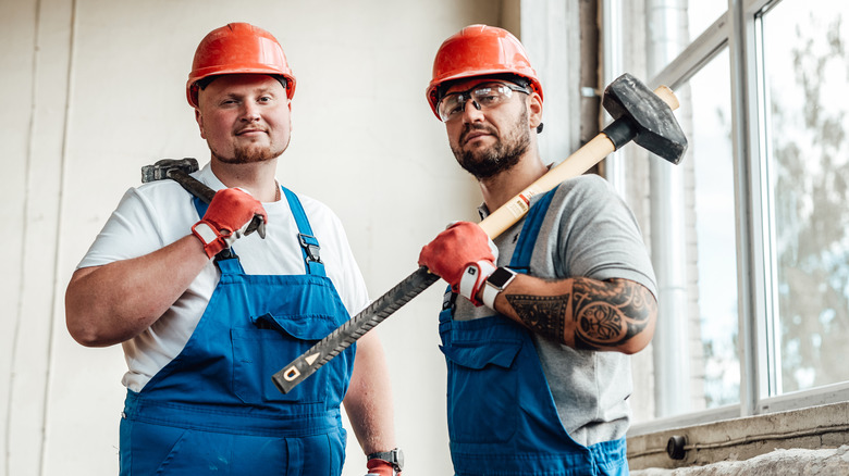 workers with sledge hammer