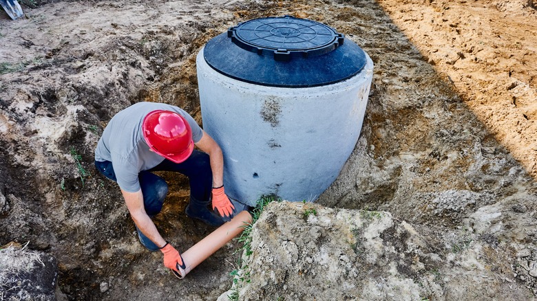 a man connecting septic tank to external disposal system