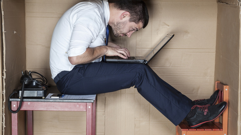 man feeling cramped tiny desk