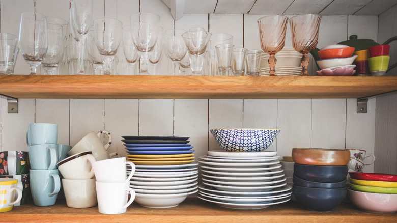 Kitchen shelves with wooden paneling.