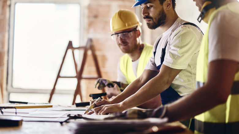 construction workers look at blueprint