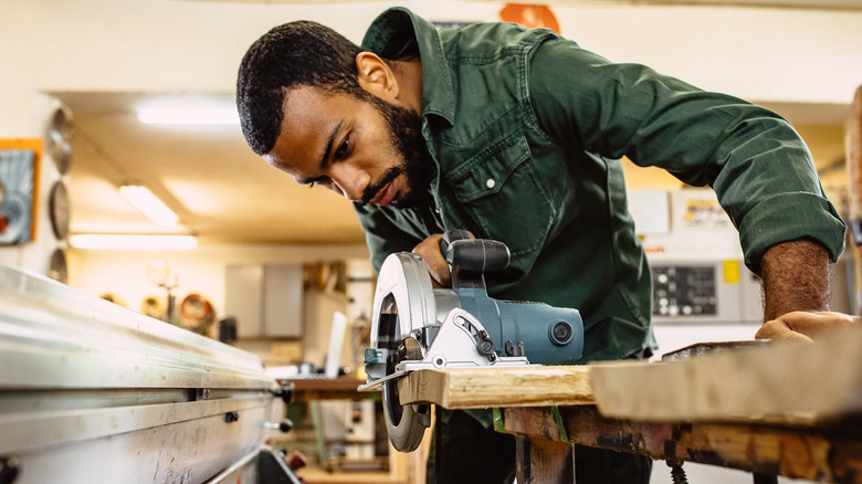 man cutting wood with circular saw