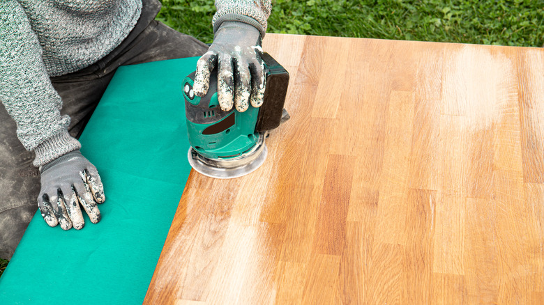 Person sanding wood table