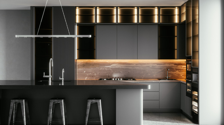 A sleek black contemporary kitchen with modern lighting fixtures.