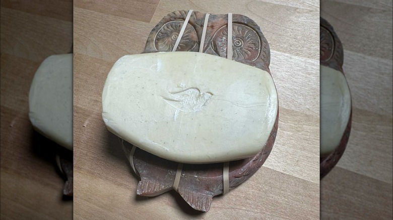 Bar of soap resting on rubber bands on top of soap dish