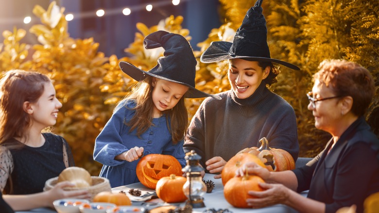 Family carving pumpkins outside