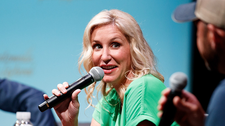 Jenny Marrs speaking into a microphone while onstage at a panel event