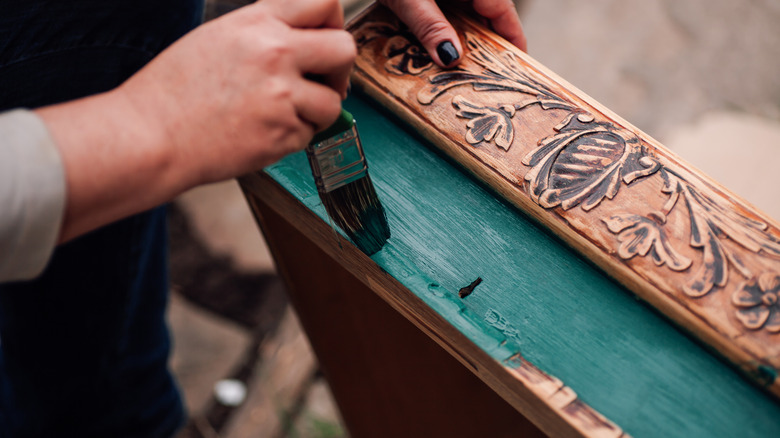 Person painting a drawer emerald green