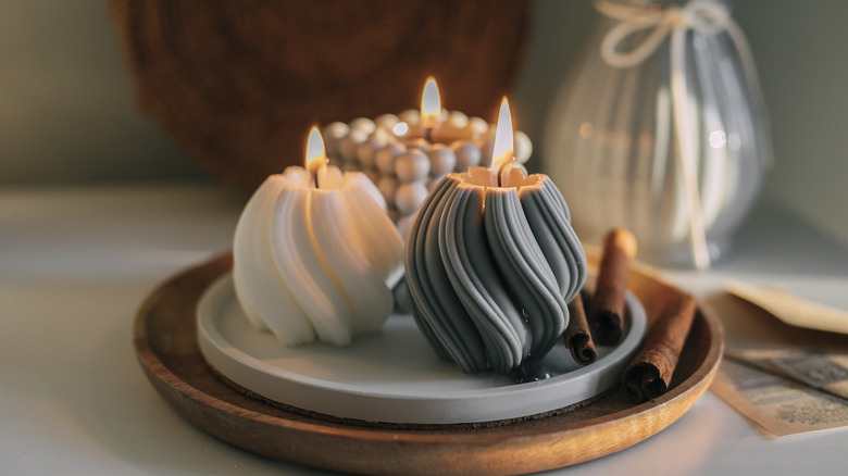 Burning candles on wooden tray