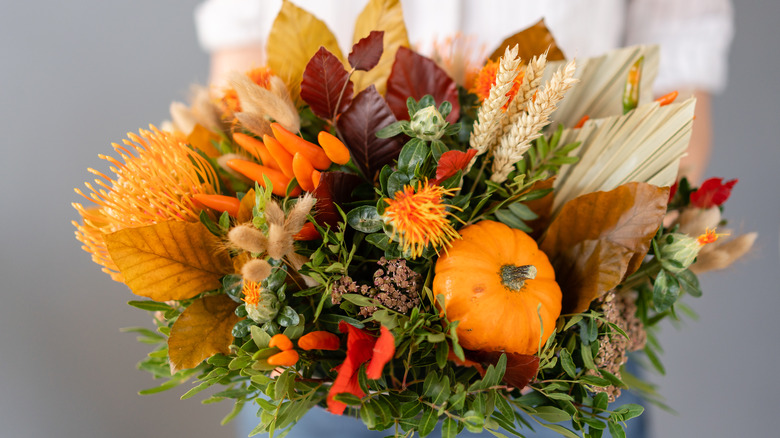 person holding fall bouquet