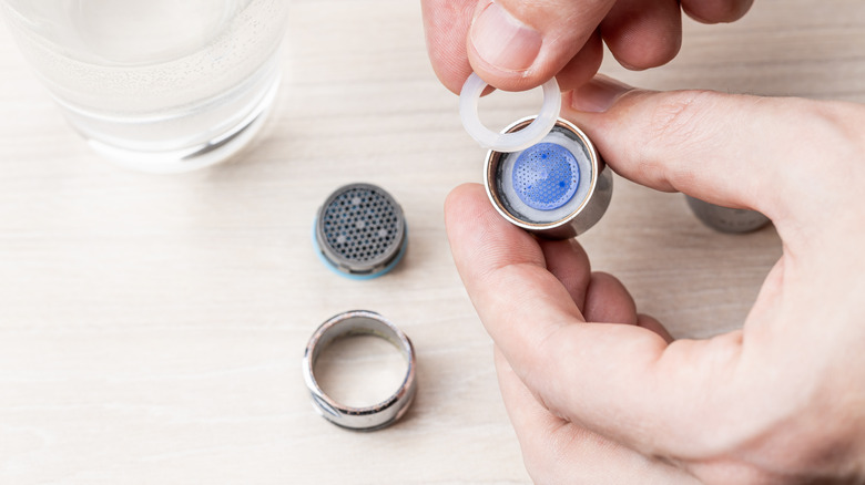 Hand holding uninstalled faucet aerator 