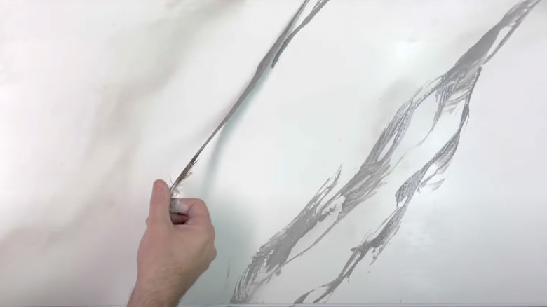 hand creating faux marble paint look with feather