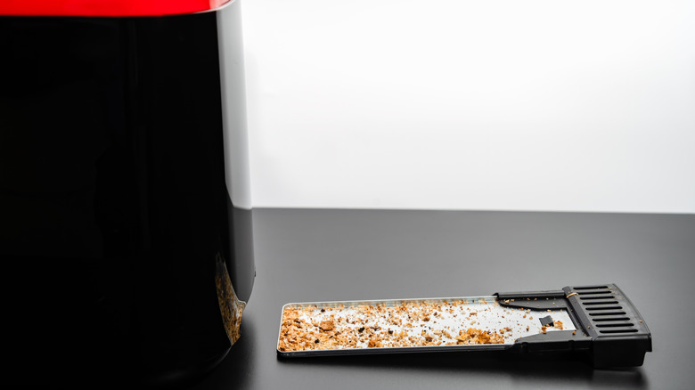 A tray full of bread crumbs from a toaster