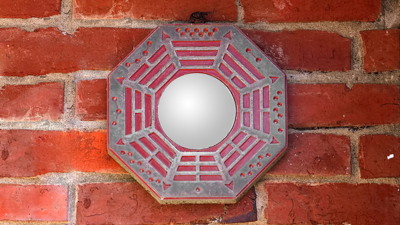 feng shui mirror on a brick wall