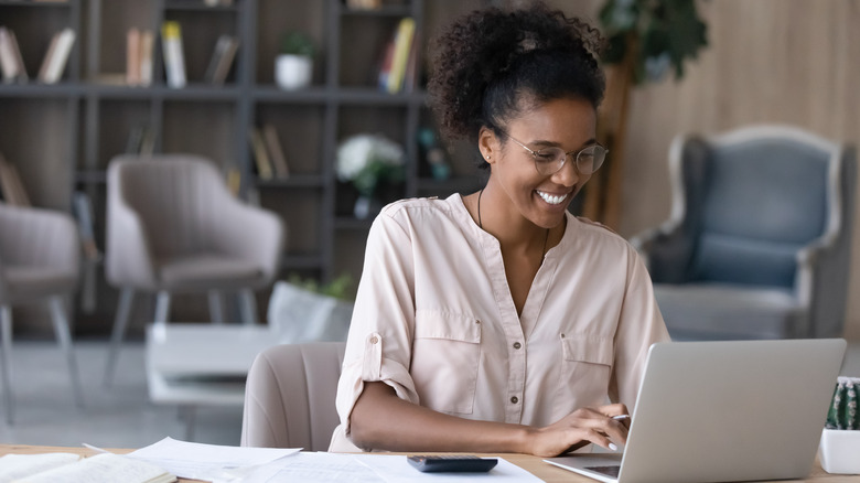 woman looks at computer at table