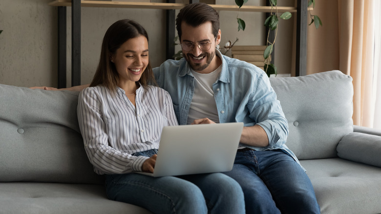 couple looking at computer on couch