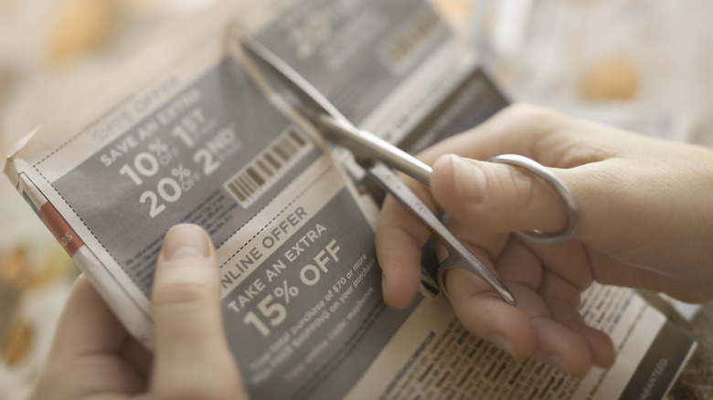 person cutting coupon