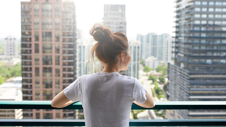 Woman standing on city balcony