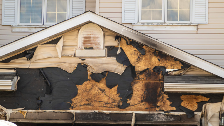 Fire damaged vinyl siding on the front of a house