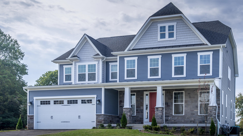 A large blue house with fiber cement shingle siding on the gables