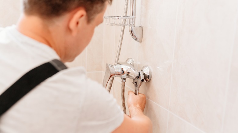 Person removing a bathtub faucet