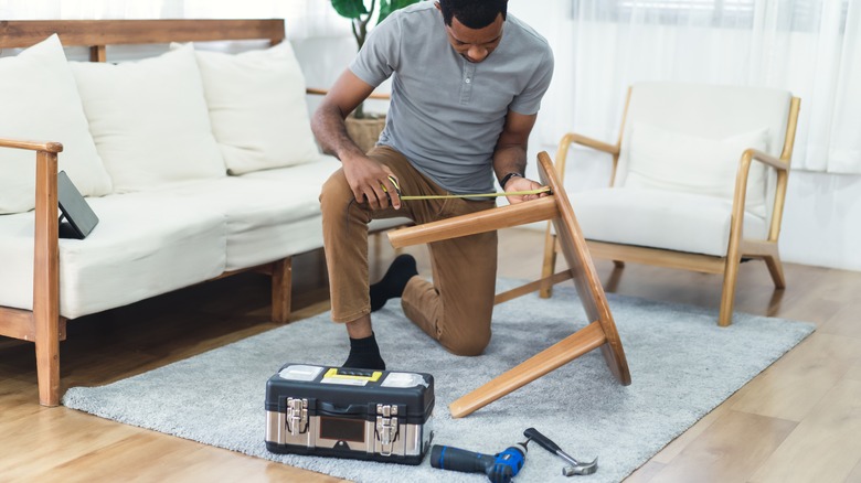 Person measuring coffee table leg