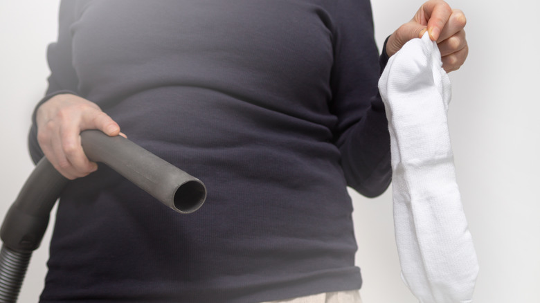 Woman holding vacuum and sock