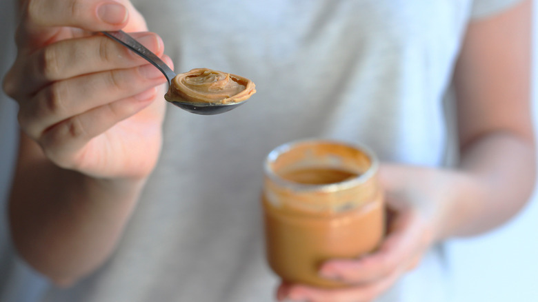 woman with spoonful peanut butter 