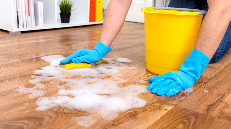 person cleaning floorboards