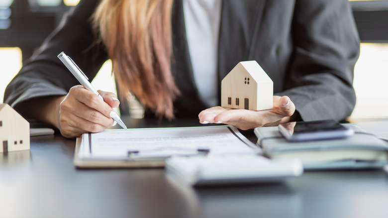 Woman holding toy house