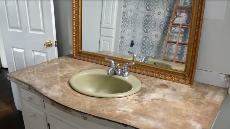 Old stone vanity and gold mirror