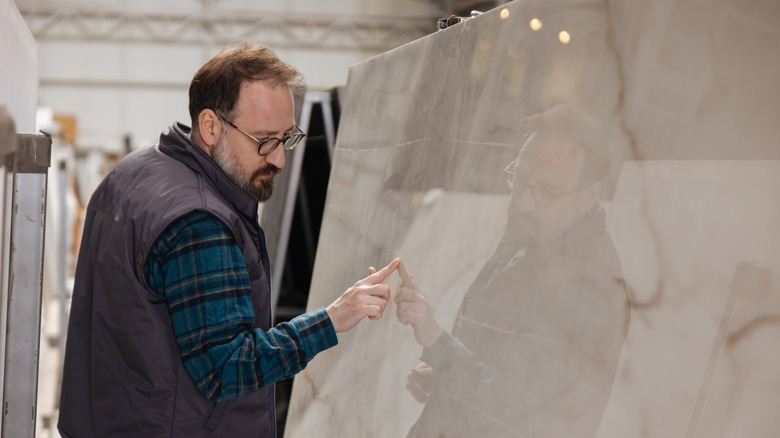 man inspecting marble slab