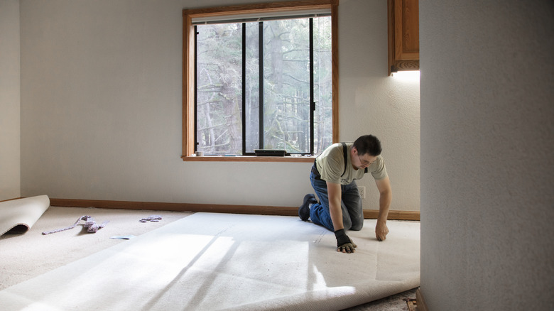 Man installs a carpet