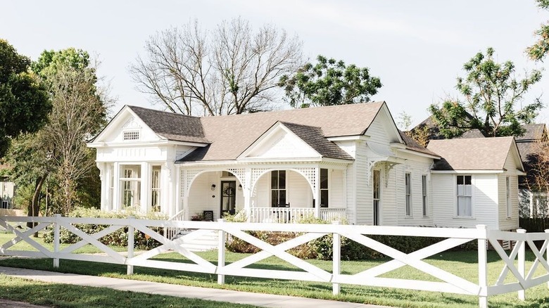 White rustic house with fence 