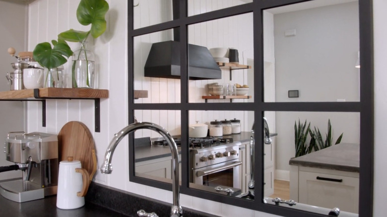 A grid style mirror over a kitchen sink