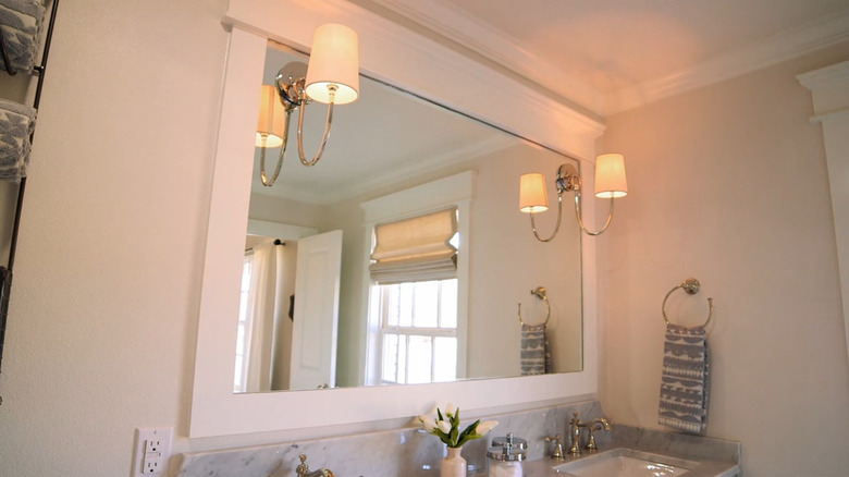 A modern bathroom mirror with attached sconces