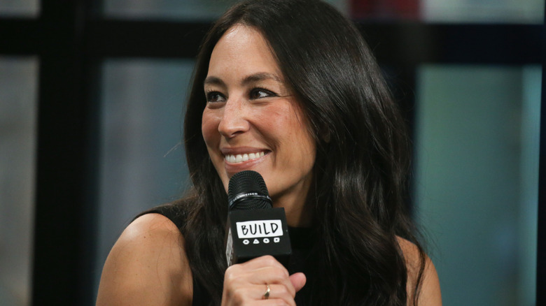 Joanna Gaines holding a microphone.