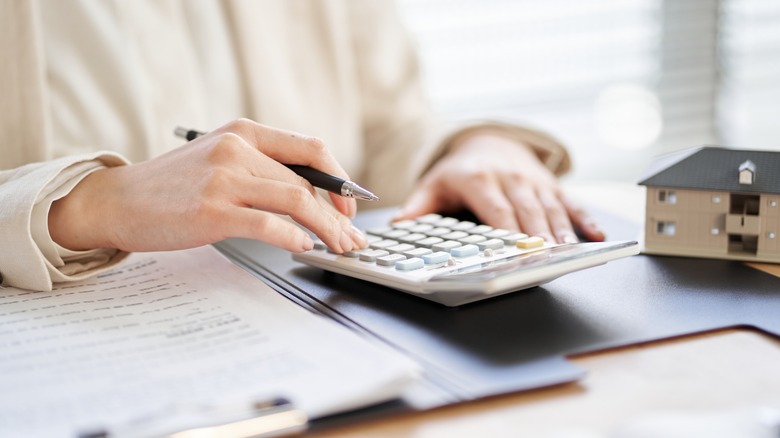 Woman working with real estate numbers and calculator