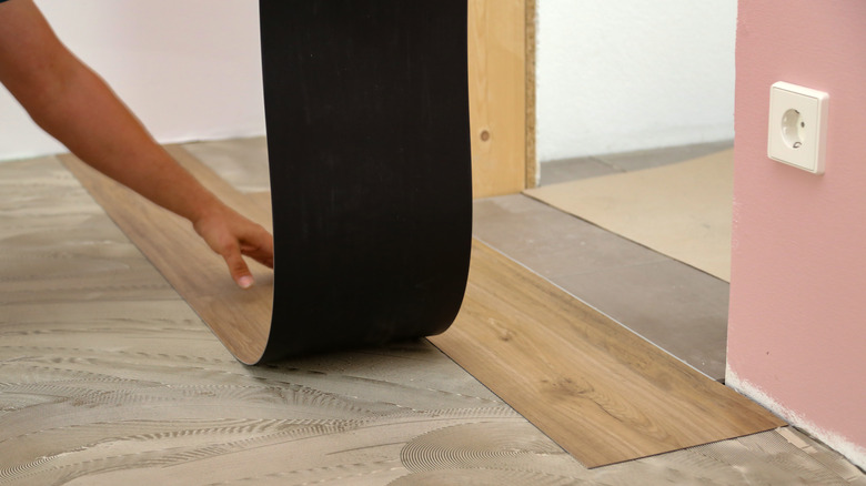 Worker installing new vinyl tile floor