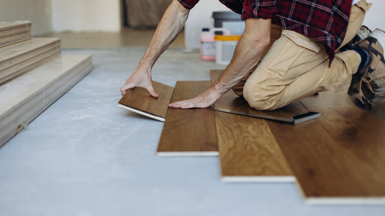 Man installing the wooden plank flooring