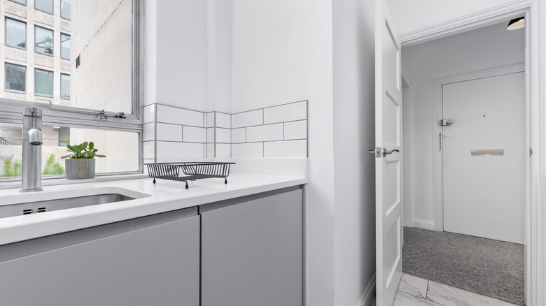 A modern gray kitchen with backsplash that extends to the corner