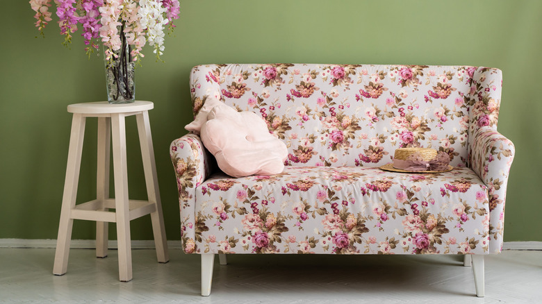 Floral couch against green wall