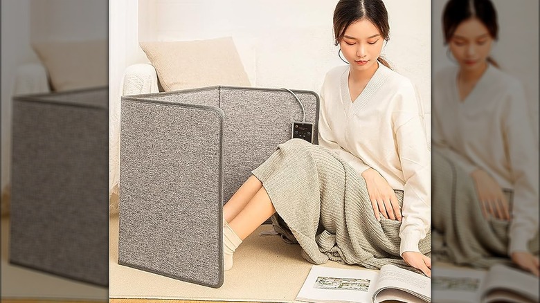 Woman reading with foldable space heater.