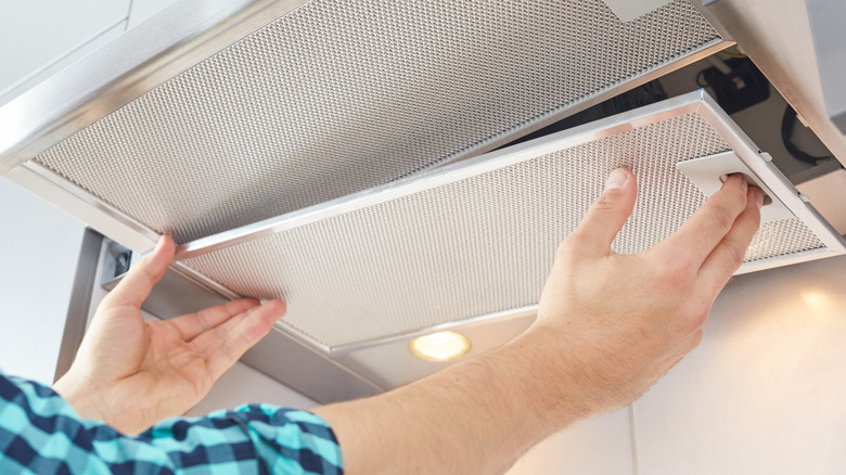 A man removing the cover of extractor fan 
