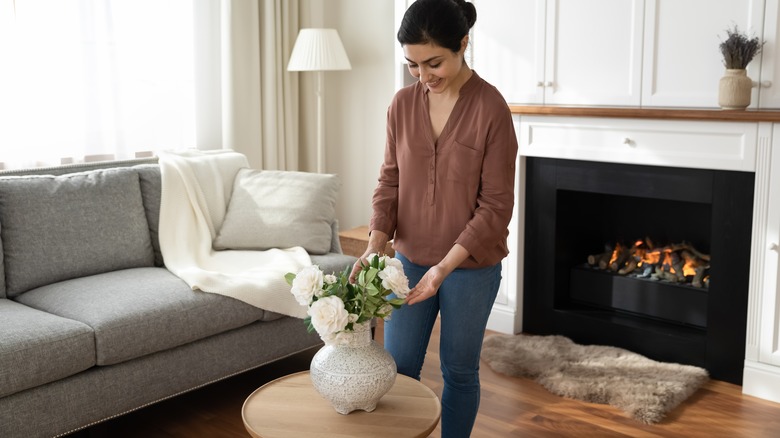 woman decorating with smaller vase