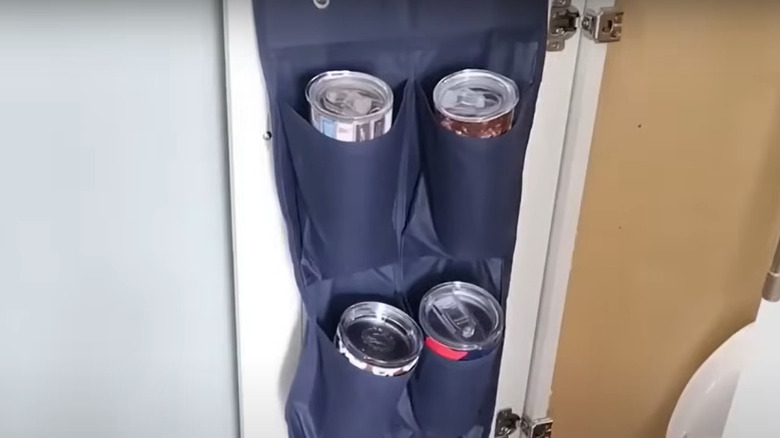 Water bottles in a shoe organizer hanging on a closet door