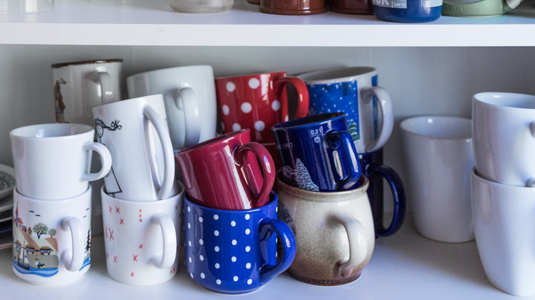 mugs stacked in kitchen cabinet