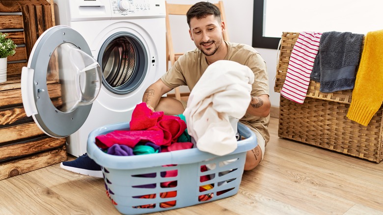 A man taking clothes out of a front-load washer